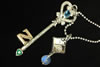 Silver and gold hand engraved key pendant with emerald, diamond and moonstone accents